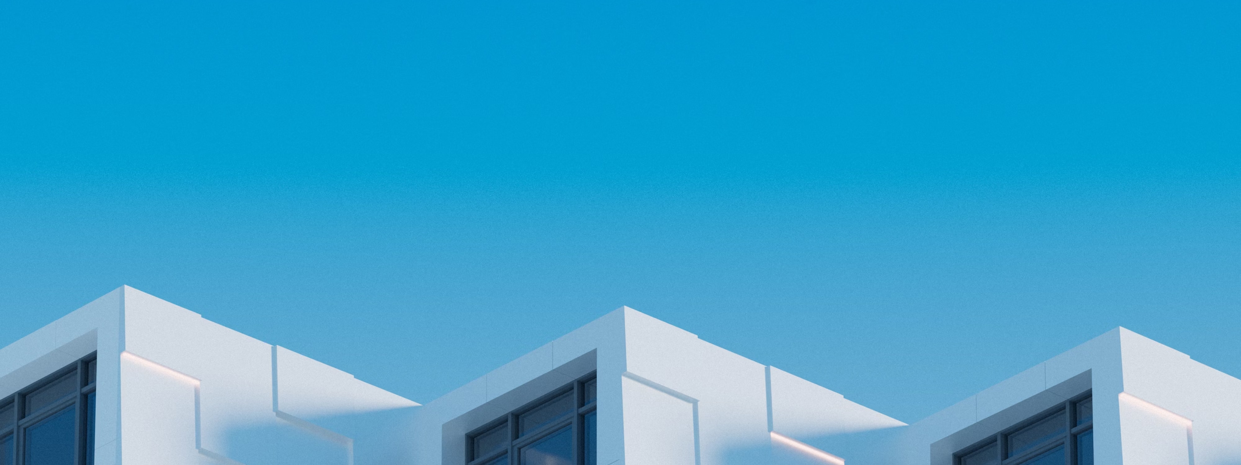 White modern building rooftops against clear blue sky