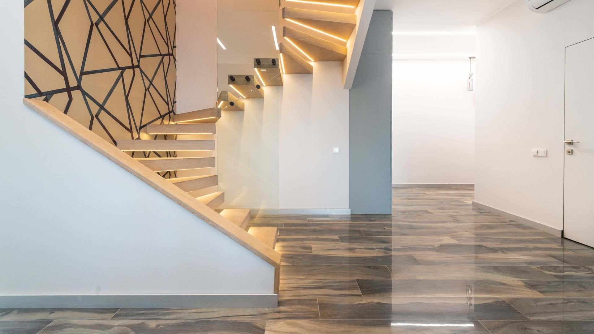 Modern wooden staircase with geometric wall and integrated LED lighting